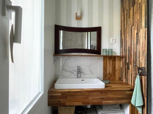 une salle de bain avec un lavabo et un miroir dans l'établissement Maison rénovée proche plage avec cour privative, vélos et équipements bébé - FR-1-426-561, à Les Sables-dʼOlonne