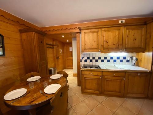 une cuisine avec des armoires en bois et une table en bois dans l'établissement Appartement 2 pièces 4 personnes à Méribel Village, pieds des pistes, piscine chauffée - FR-1-411-946, à Les Allues