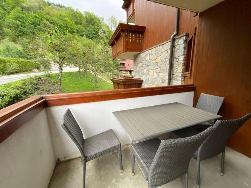 un balcon avec une table et des chaises sur un balcon dans l'établissement Appartement 2 pièces 4 personnes à Méribel Village, pieds des pistes, piscine chauffée - FR-1-411-946, à Les Allues