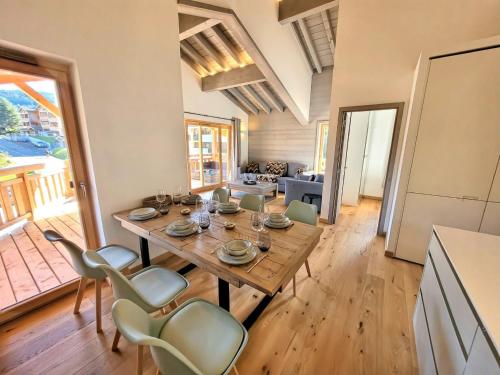 une cuisine et une salle à manger avec une table et des chaises en bois dans l'établissement Les Gets : Appt élégant 3 chbres, balcon, garage, 6 pers - FR-1-598-175, aux Gets