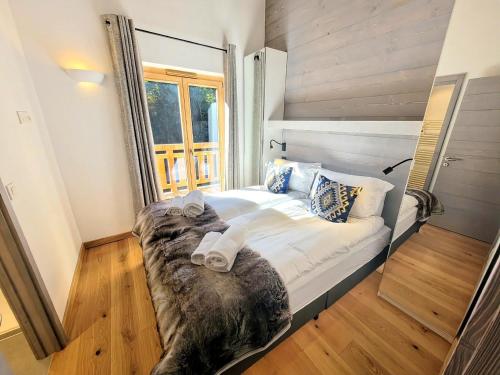 un grand lit dans une chambre avec une fenêtre dans l'établissement Les Gets : Appt élégant 3 chbres, balcon, garage, 6 pers - FR-1-598-175, aux Gets