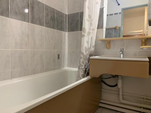 une salle de bain avec une baignoire blanche et un lavabo dans l'établissement Studio économique pour 3 pers avec balcon à Les Menuires, Reberty 1850 - FR-1-452-391, aux Menuires