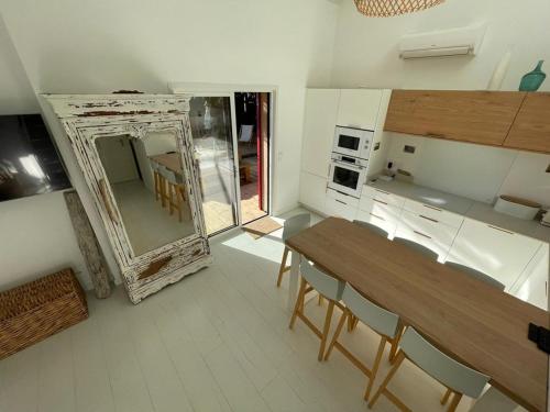 a kitchen with a mirror and a table and chairs at Villa rénovée avec accès plage, clim, WiFi, parking - FR-1-413-248 in Capbreton