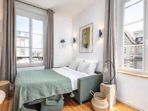 une petite chambre avec un lit et deux fenêtres dans l'établissement Charmant studio à deux pas de la plage à Cabourg - FR-1-788-32, à Cabourg