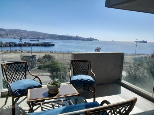 Un balcón con sillas y una mesa y vista al mar. en HOM I Espectacular depto 2D2B para 4PAX frente al Mar 0302, en Valparaíso