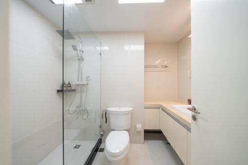 a bathroom with a toilet and a shower and a sink at Shanghai Yi Du B&B - Near Nanjing West Road commercial district, 350 walk from the Natural History Museum subway in Shanghai