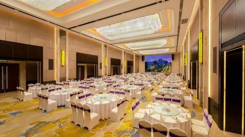 a large banquet hall with white tables and chairs at Grand Metropark Hotel Chongqing in Chongqing