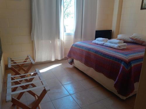 Un dormitorio con una cama con toallas. en Aquamarinas Departamentos, en Playas Doradas