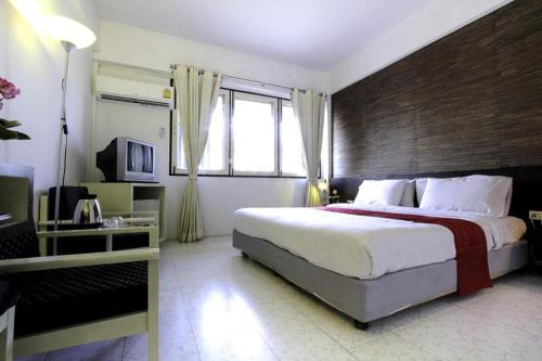 a bedroom with a large bed and a large window at The Ratchathani Hotel in Ubon Ratchathani