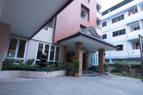 a white building with a red roof and a building at At Home at Udon in Udon Thani