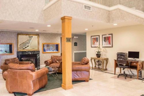 a living room with leather furniture and a fireplace at Econo Lodge Raleigh near Walnut Creek Amphitheatre in Raleigh