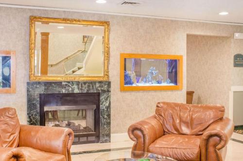 a living room with two leather chairs and a fireplace at Econo Lodge Raleigh near Walnut Creek Amphitheatre in Raleigh