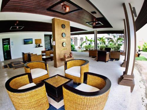 a lobby with wicker chairs and a table at Ocean Breeze Residence in Khao Lak