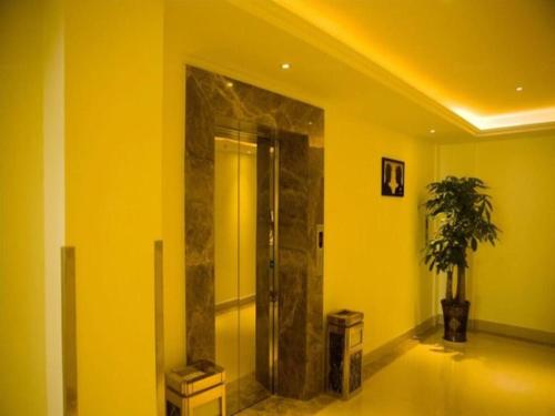 un bagno con doccia su una parete gialla di GreenTree Inn Xiangshan Transportation Center Bai Hua Road a Xiangshan