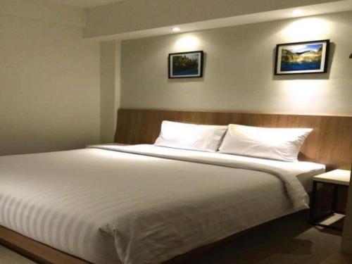 a bedroom with a large bed with white sheets and pillows at Hart Hotel Arjuna in Gili Trawangan