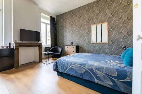 une chambre avec un lit bleu et une télévision dans l'établissement Les Appart'Hôtels Du Calaisis - 102 Shadow, à Calais