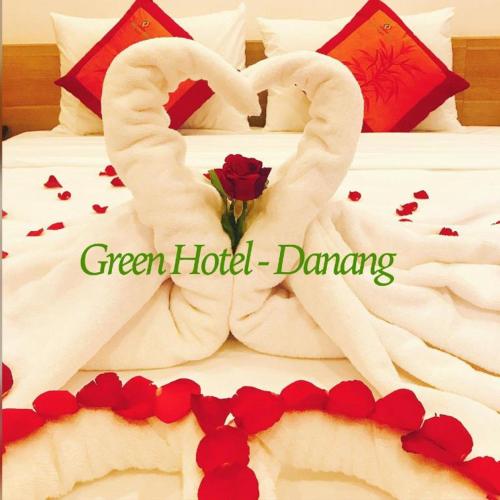 a bed with two swans made to look like hearts at Green Hotel Da Nang in Da Nang