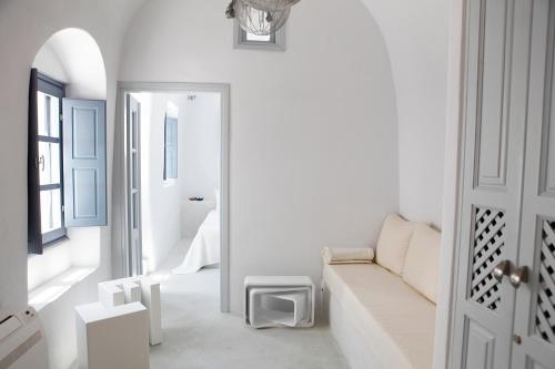 a white living room with a couch and a window at Santoniro Villa in Fira