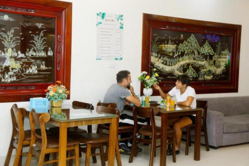 a man and a woman sitting at a table at Luxury Airport Hotel & Spa in Phu Lo Dong