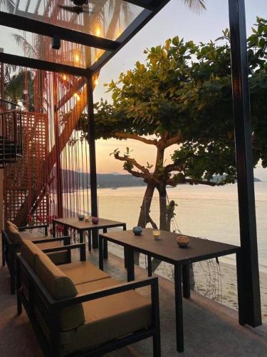 a patio with tables and chairs with a view of the water at Sea Suite Villa in Chaweng