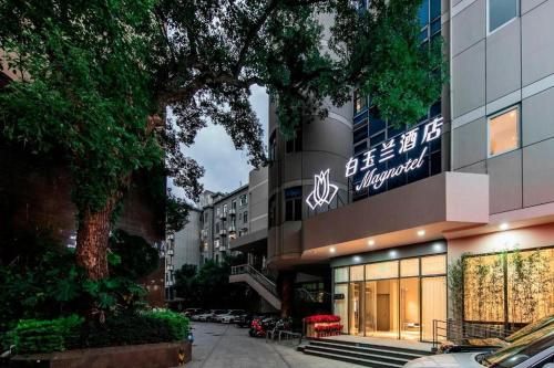 a building with a sign on the side of it at Magnotel Fuzhou Wuyi Road Sanfangqixiang in Fuzhou