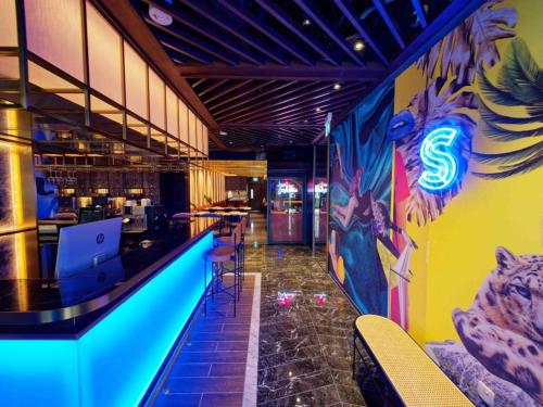 a bar in a restaurant with a mural on the wall at Hotel Soloha @ Chinatown in Singapore