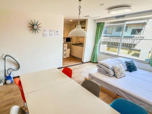 a room with a bed and a table and a window at Hostel Inn Kyoto Gion in Giommachi