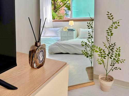 a bedroom with a bed and a clock in a mirror at GuRoom House Seoul in Seoul