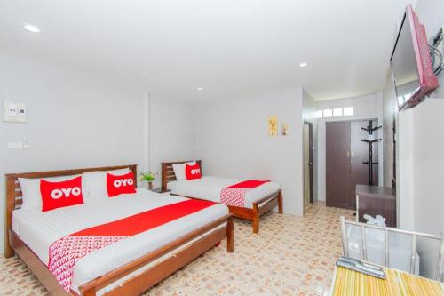 a hotel room with two beds and a television at OYO 650 At Night Pranburi in Hua Hin