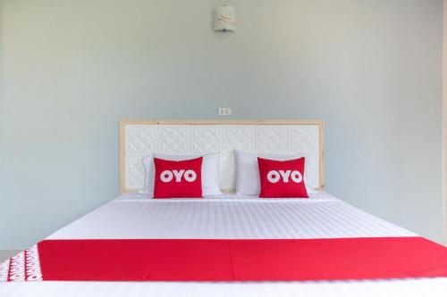 a large white bed with red pillows on it at OYO 674 Greenery Home in Ranong