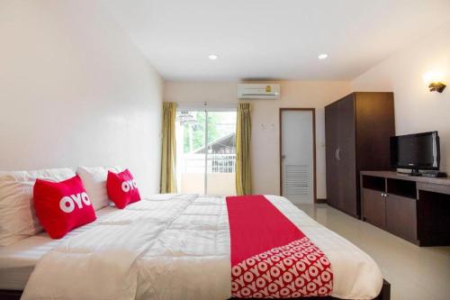 une chambre avec un grand lit avec des oreillers rouges dans l'établissement OYO 904 Mai Thai Place, à Hua Hin