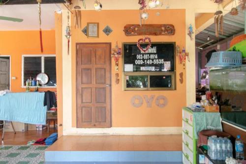 a store with an orange wall with a door at OYO 931 Sor Chareanpanit in Pattaya Central