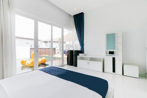a bedroom with a large bed and a large window at Capital O 1009 Leleaf Valley Pool Villa Resort Hua Hin in Hua Hin