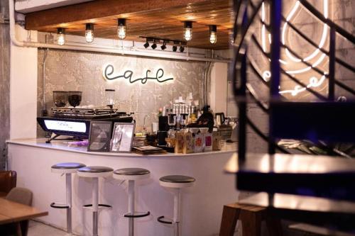 a bar with stools in front of a counter at The Singha Hotel - Korat in Nakhon Ratchasima