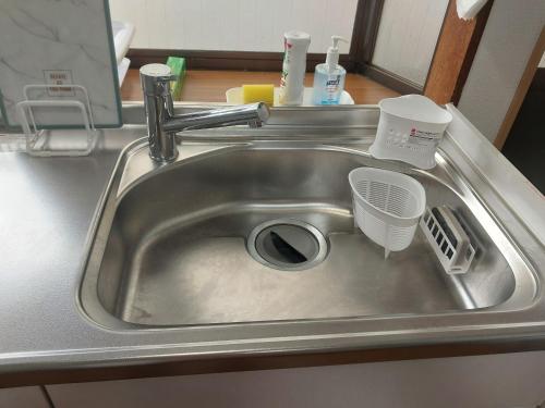 a sink with a strainer in the middle of it at 自炊の出来るキッチン付きの貸切宿-Joyjoy奄美 in Setouchi
