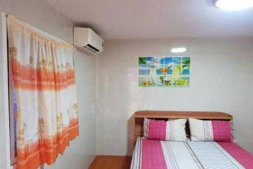 une chambre avec un lit et un tableau au mur dans l'établissement OYO 75352 Hotel Family House And Resort Phetchaburi, à Ban Lahan Bon