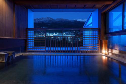 a swimming pool with a view of the mountains at Yuuyu No Sato Yusa in Yamagata