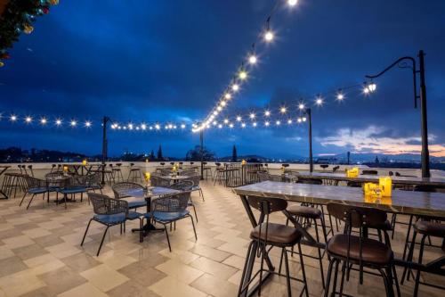 eine Terrasse mit Tischen, Stühlen und Lichtern in der Nacht in der Unterkunft Da Lat Prince in Khu Chi Lăng