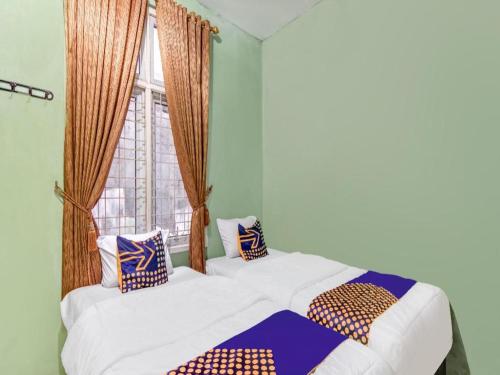 Ένα ή περισσότερα κρεβάτια σε δωμάτιο στο Hotel O Nayla Homestay Syariah Near Koro Koro Panam, Karaoke, Pool, & Cafe