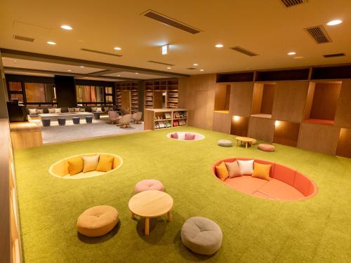 a large room with chairs and tables on a green carpet at Yuuyu No Sato Yusa in Yamagata