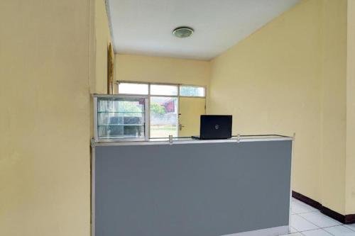 a room with a desk with a laptop on it at Hotel O P3 Guest House in Bandung