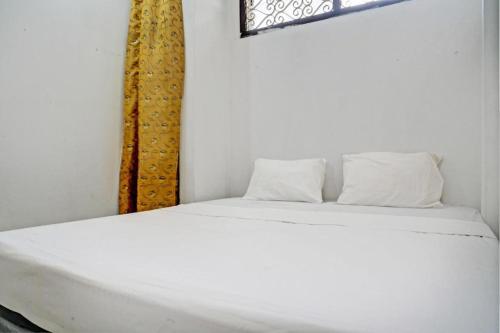 białe łóżko z 2 poduszkami w pokoju w obiekcie SPOT ON 93475 Garuda Homestay Syariah w mieście Sukabumi