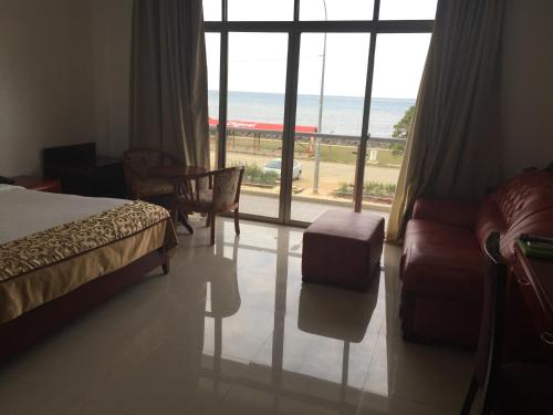 a bedroom with a bed and a view of the ocean at Emerald Hotel & Restaurant in Nuku‘alofa