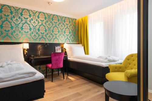 a hotel room with two beds and a desk at Thon Hotel Rosenkrantz Bergen in Bergen