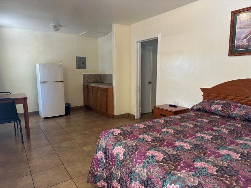 a bedroom with a bed and a refrigerator at Kentucky Motel in Bradenton