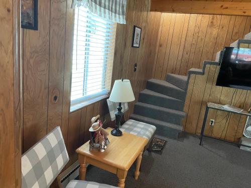a living room with a table and stairs with a lamp at White Owl Retreat Yellowstone Grand Teton in Island Park