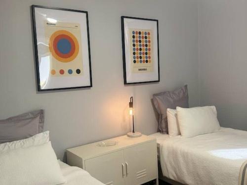 a bedroom with two beds and a table with a lamp at The Warra House in Dubbo
