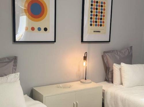 a bedroom with two beds and a table with a lamp at The Warra House in Dubbo
