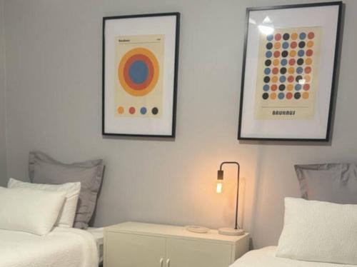 a bedroom with two beds and two pictures on the wall at The Warra House in Dubbo