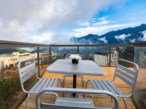 a table and chairs on a balcony with a view at Azalea Sapa Hotel in Sa Pa